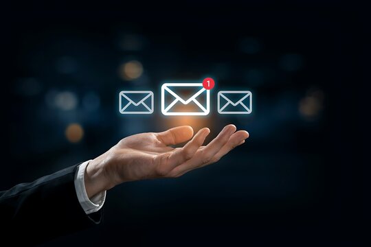 Person in a suit holding a glowing email notification icon with a red alert badge in hand