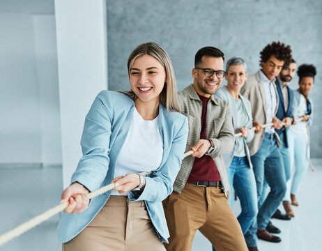 Portrait of a young  businesspeople pulling a rope in the office