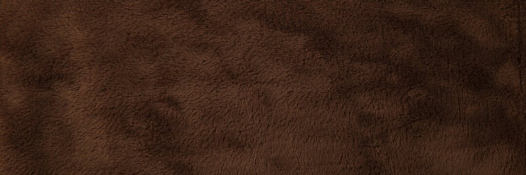 Dark brown suede leather texture, soft velvet fabric background, luxury matte material for fashion and upholstery design