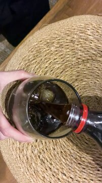 Close up of cold refreshing Fernet and cola cocktail in a glass with ice cubes and condensation, classic Argentine drink for a night out