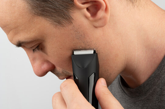 Young man trim his beard