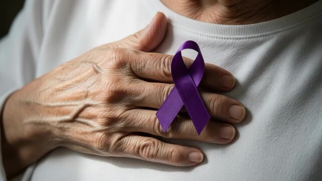 Person holding a purple awareness ribbon