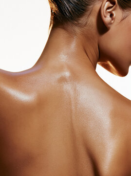Nahaufnahme des gepflegten R&uuml;ckens einer Frau mit gl&auml;nzender Haut vor hellem Hintergrund. Beauty, Hautpflege, Wellness, K&ouml;rperpflege, Spa und nat&uuml;rliche Sch&ouml;nheit.