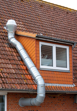 Large Metal Ventilation Duct Installed on Tiled Roof of Residential Building