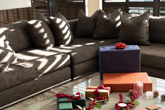 Navy-blue gift box is sitting on glass table in living room, stripes crossing sofa and reflections