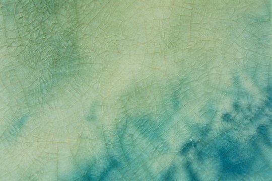 Glazed ceramic surface showing crackle texture in teal