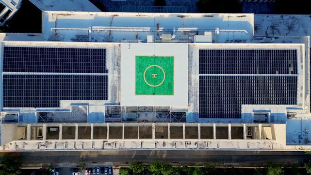 Rooftop solar panels and helipad aerial top down view