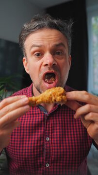 Junk food advertisement concept. Man eating fried chicken, enjoying fast food.