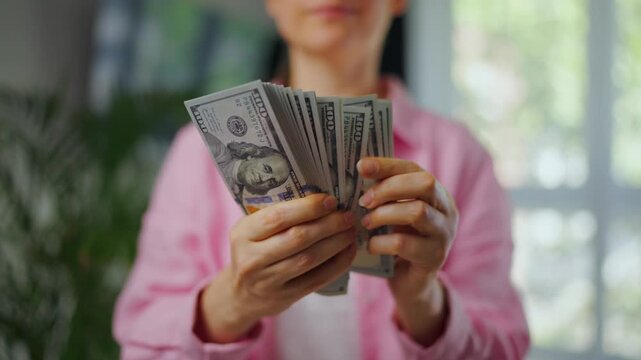 Woman counting US Dollar bills, close-up. Concept of investment and success