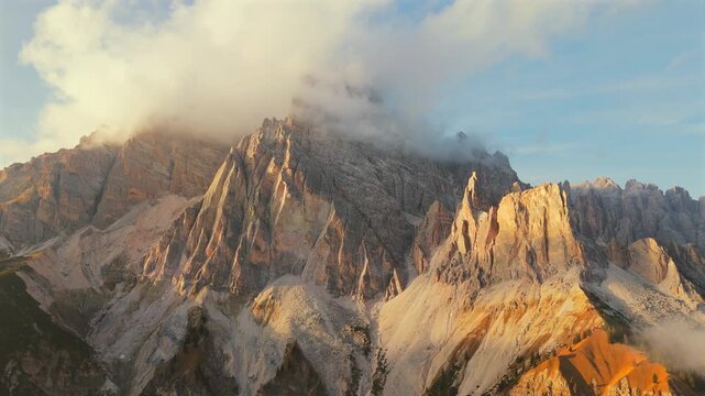 Aerial view of high mountain range covered with clouds in Dolomites, Italy
