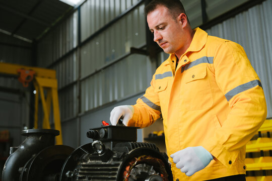 Focused conceptual engineering in industrial plants. concentrated worker inspects machine engine with professional determination