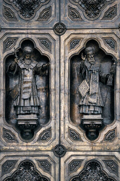 Bronze relief sculpture of an Orthodox bishop on a church door. Medieval religious architecture and ornate metalwork. Artistic details of saints for history and culture concept