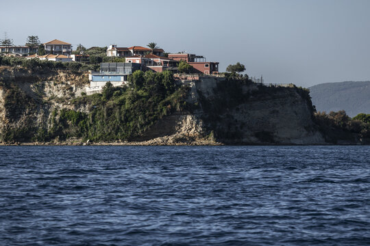 View of buildings perched on the cliffside overlooking the sea in Zakinthos, Greece.