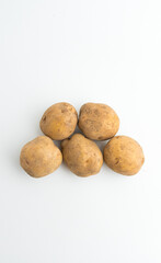 Fototapeta premium Small pile of fresh raw brown baby potatoes isolated on white background