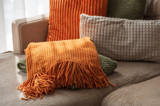 Cozy autumn home decor arrangement with textured pillows and plush throws