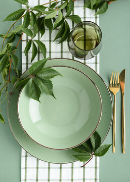 Elegant Thanksgiving Table Setting with Fresh Greenery and Gold Cutlery for a Festive Gathering