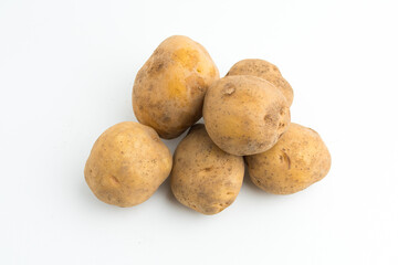 Fototapeta premium Small pile of fresh raw brown baby potatoes isolated on white background
