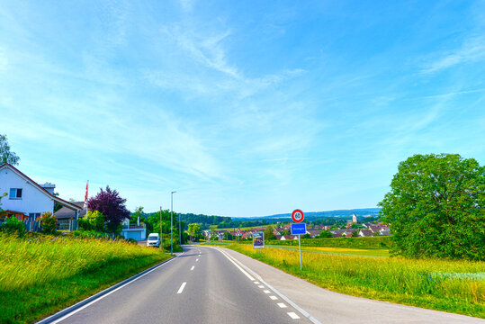 Fahrt am Ortseingang von Ossingen mit blauem Ortsschild und Tempolimit 60, Kanton Z&uuml;rich, Schweiz