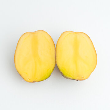 Fresh cut potato halves and whole potatoes isolated on a pure white background