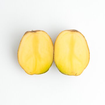 Fresh cut potato halves and whole potatoes isolated on a pure white background