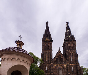 Fototapeta premium Romanesque Rotunda of St Martin and Neo-Gothic Basilica of St Peter and Paul at Vysehrad in Prague, Czech Republic, under an overcast sky.