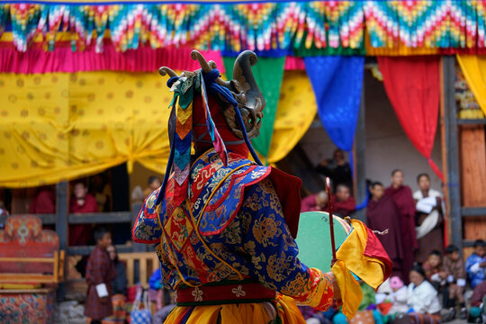 Bhutan, In the village of Bumthang, monks in colorful costumes dance during the annual Jakar festival. blurred background