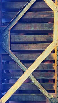 Underneath view of a train passing over the wooden tracks of a bridge establishing shot