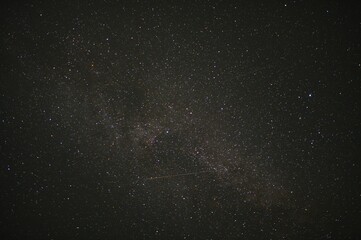 Obraz premium Night sky showing a meteor streaking across the milky way