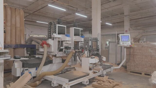 CNC woodworking machine milling a precision edge profile on a wooden board. Automated routing process creates an interlocking joint for furniture manufacturing and wood assembly. 