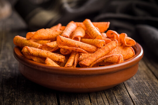 Spicy Rolled Corn Snacks in Bowl . Crunchy Red Chili Snack Chips for Party or Snack Time
