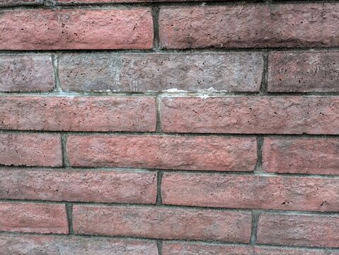 Weathered red brick wall texture with aged mortar and white stains