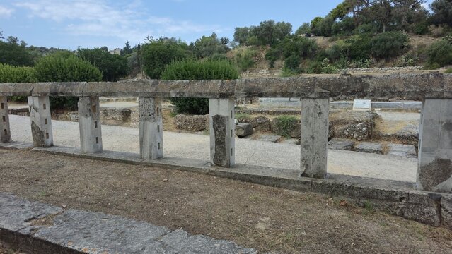 Ancient Agora, Athens, Greece - 8 July 2026. Stone fence of the Monument of the Eponymous Heroes, with upright posts bordering excavated foundations.