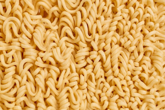 Close-up of uncooked instant ramen noodles in a tangled pattern