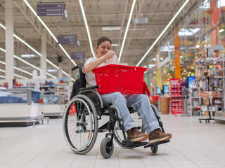 Obraz premium A Caucasian woman in a wheelchair buys fruit at a supermarket.