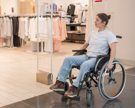 A Caucasian woman in a wheelchair shopping at a mall. 