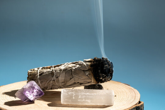sage smudge stick with amethyst and selenite for spiritual cleansing on wooden slab