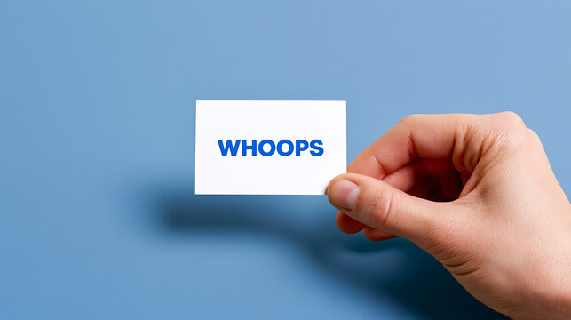 A hand holds a white card displaying the word "WHOOPS" in bold blue text, set against a solid blue background, signifying an error or mistake