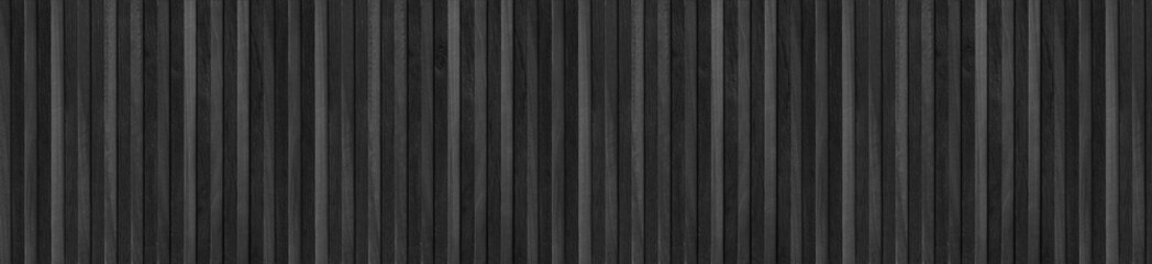 Vertical black wooden slats arranged in a seamless wide panoramic panel pattern. © EdisonArt