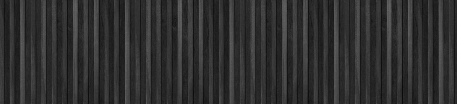 Vertical black wooden slats arranged in a seamless wide panoramic panel pattern.