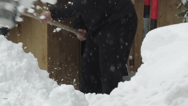 Man shoveling deep snow after winter blizzard