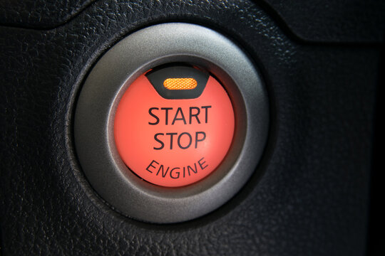 close up car engine start. Car engine push start stop button ignition remote starter. Car dashboard: black engine start stop button, car interior details. Soft focus