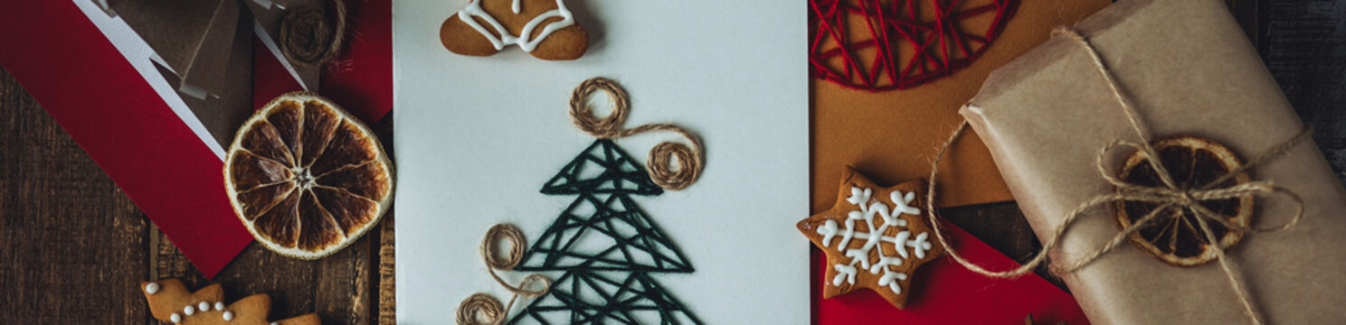 Banner. Traditional Christmas handmade crafted postcard, gingerbread cookies. Wooden background. Festive mood, cozy home atmosphere. Family time, holiday leisure. Natural materials, zero waste