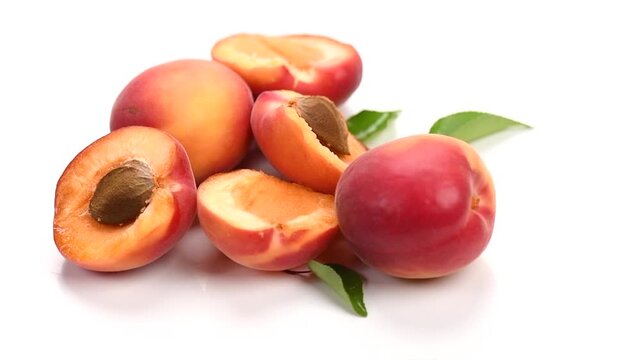 Apricots. Close-up of fresh organic apricot fruits isolated on white background. Fresh bio apricot with leaves, rotating 