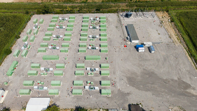 Aerial view of the BESS SERRE TAVAZZANO battery energy storage system with rows of green containers and electrical infrastructure in Tavazzano con Villavesco, Lombardy, Italy.