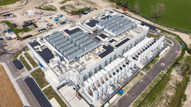 Aerial view of Vantage Data Centre - MXP1 featuring modern industrial architecture, rooftop solar panels, and cooling infrastructure in Melegnano, Lombardia, Italy.