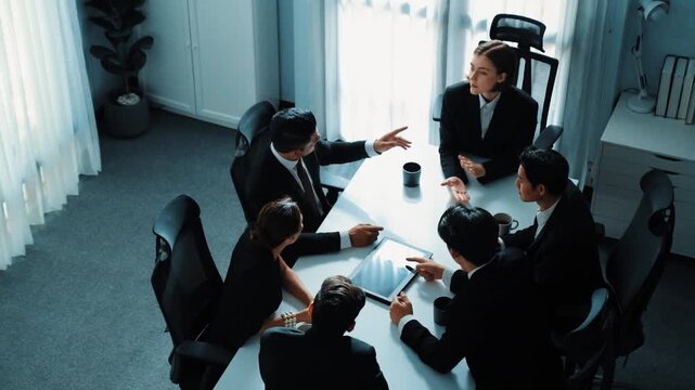 Top view of diverse business team discuss about marketing idea while businessman analyze financial graph from tablet at meeting room. Group of smart team brainstorm idea at conference. Directorate.