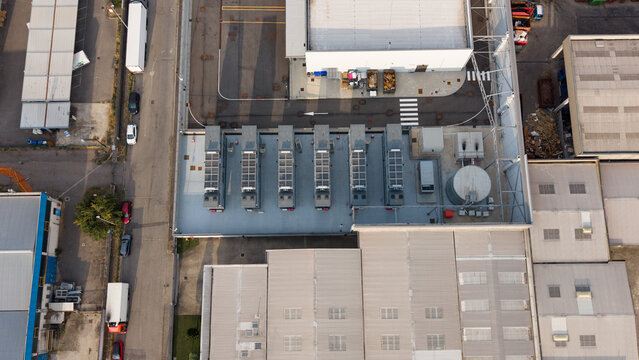 Aerial view of Stack Infrastructure MIL03 data center facility in Siziano, showing rooftop cooling units, industrial buildings, and surrounding infrastructure in Siziano, Lombardia, Italy.
