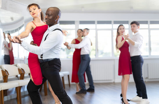 Couple of adult man and adult woman dancing tango in studio