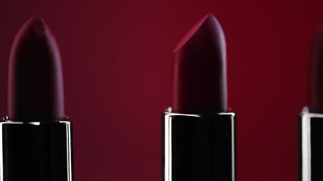 Red Lipstick set rotating. Matte red Colorful Lipsticks on red background. Red lipstick tints palette, Professional Makeup and beauty. Beautiful Make-up concept. Lipgloss. Lipsticks closeup 