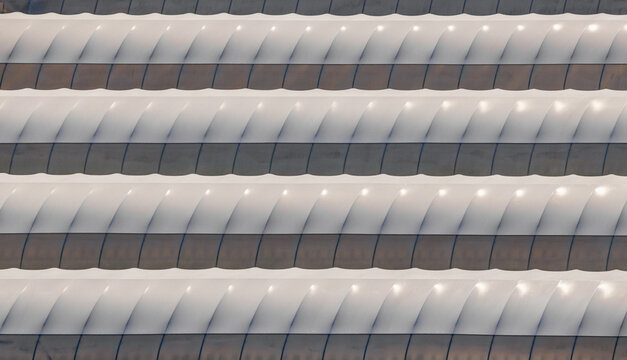 Aerial view of rows of agricultural greenhouse tunnels creating repetitive geometric patterns in a commercial plant nursery in Loriol-sur-Drome, Auvergne-Rhone-Alpes, France.